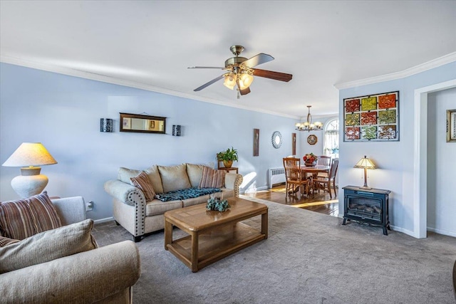 living room featuring ornamental molding, radiator, ceiling fan with notable chandelier, and carpet flooring