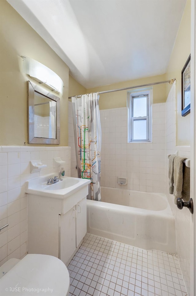 full bathroom featuring shower / bath combination with curtain, toilet, vanity, tile patterned floors, and tile walls