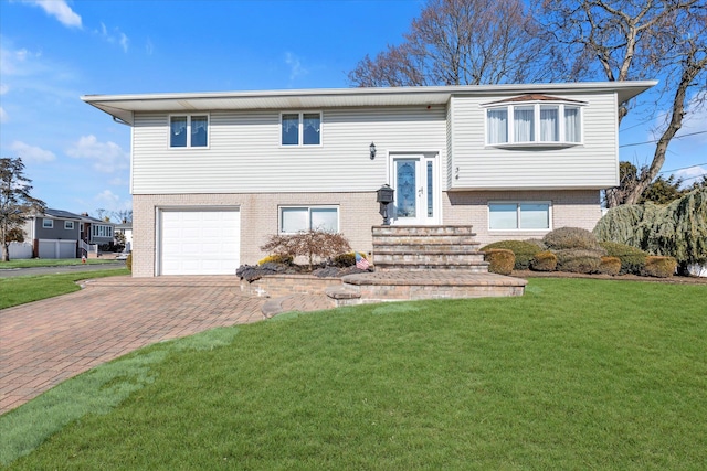 bi-level home featuring a garage and a front lawn