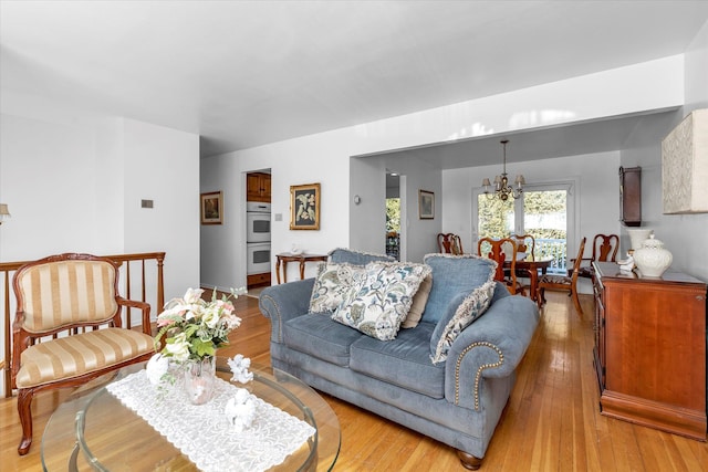 living room featuring an inviting chandelier and light hardwood / wood-style floors