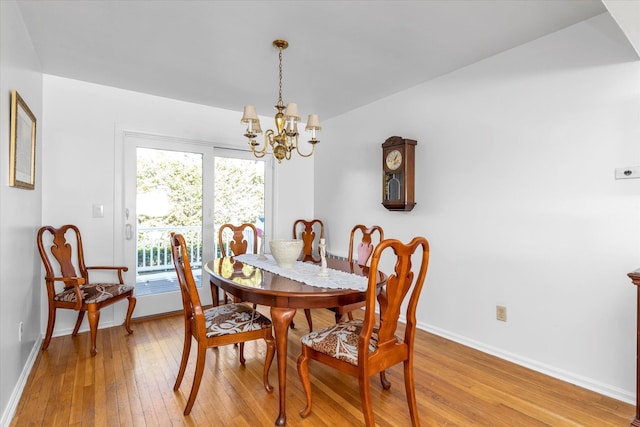 dining space with a wealth of natural light, light hardwood / wood-style floors, and a chandelier