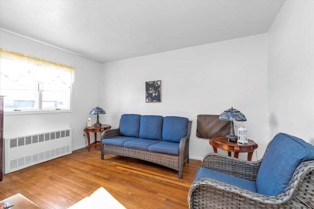 living area featuring hardwood / wood-style flooring and radiator heating unit