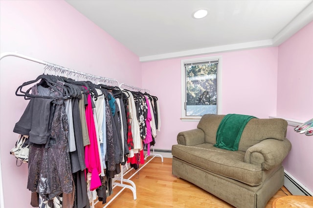 spacious closet with wood-type flooring and a baseboard heating unit