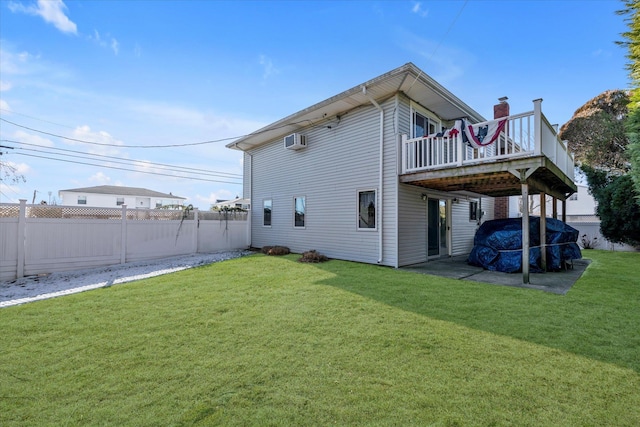 rear view of house with a yard, a wall unit AC, and a deck