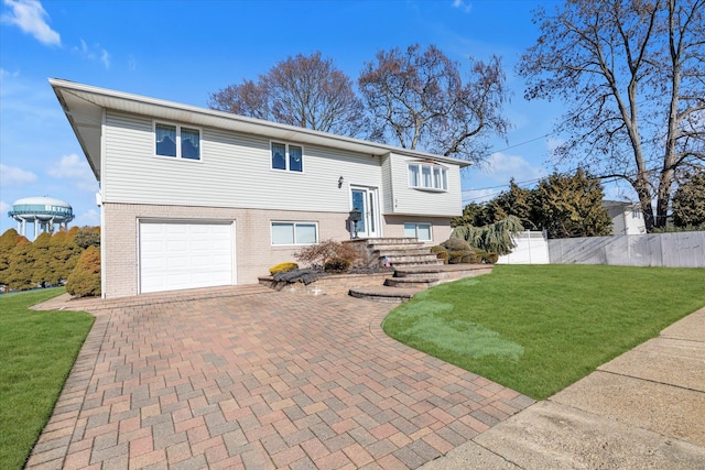 raised ranch featuring a garage and a front lawn