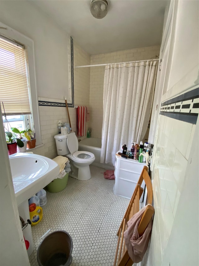 bathroom with tile patterned floors, tile walls, toilet, and shower / bath combination with curtain