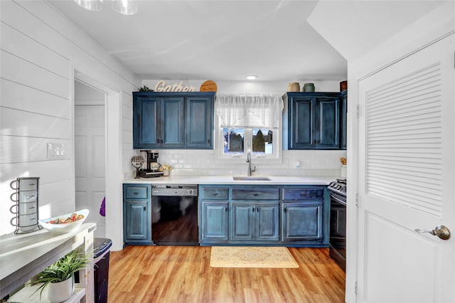 kitchen with light hardwood / wood-style floors, sink, black dishwasher, and blue cabinetry