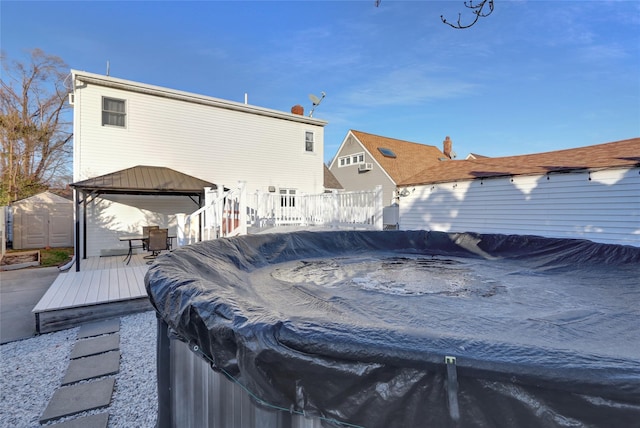 back of property with a shed, a gazebo, and a wooden deck