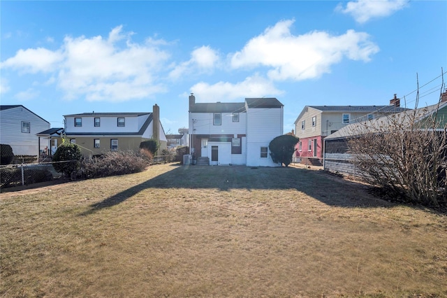 rear view of property with a lawn