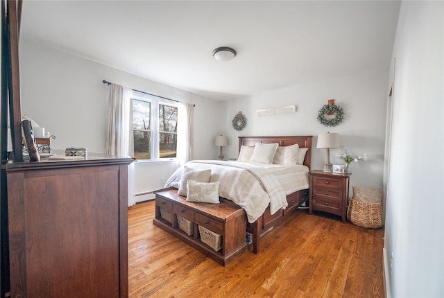 bedroom with a baseboard radiator and hardwood / wood-style floors