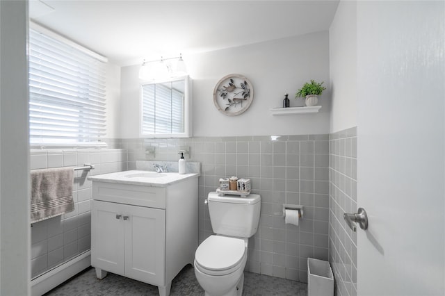 bathroom with tile walls, tile patterned flooring, toilet, and vanity