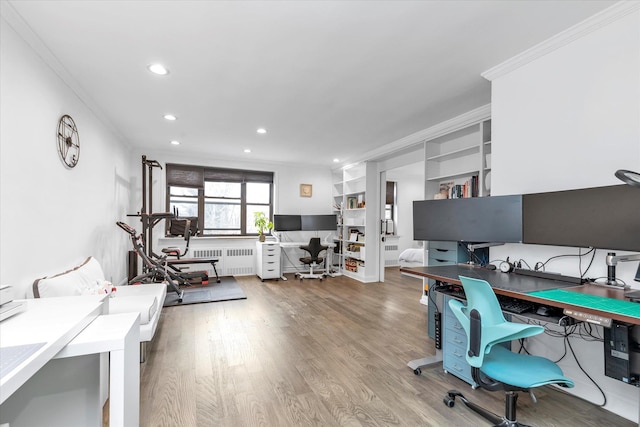 home office with crown molding, light hardwood / wood-style flooring, and radiator heating unit