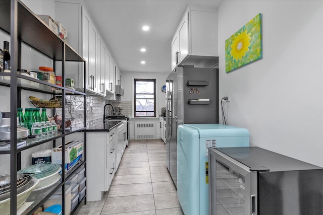 laundry room with light tile patterned floors and radiator