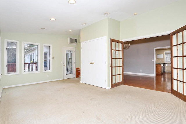 empty room with vaulted ceiling, french doors, and carpet flooring