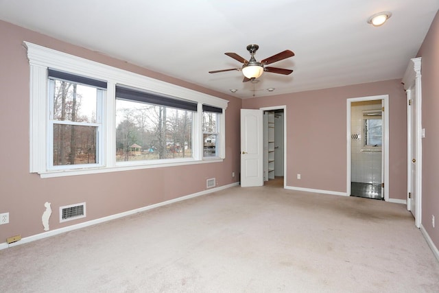 unfurnished bedroom featuring ceiling fan, light carpet, and connected bathroom