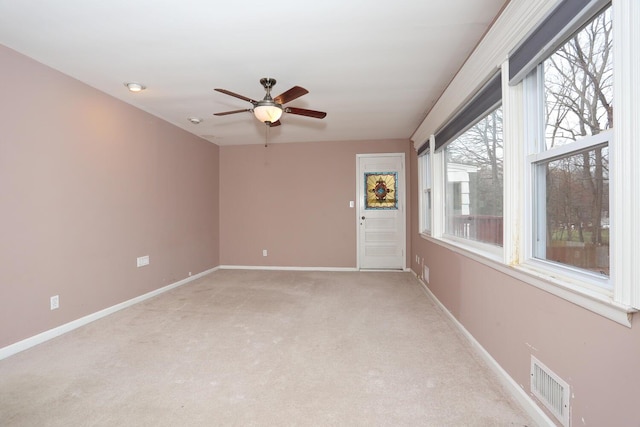 carpeted spare room featuring ceiling fan