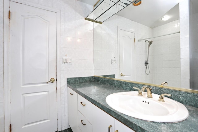 bathroom featuring a shower, vanity, and tile walls