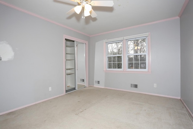 unfurnished bedroom featuring ornamental molding, carpet floors, ceiling fan, and a closet