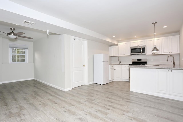 kitchen with stainless steel appliances, sink, white cabinetry, light stone counters, and pendant lighting