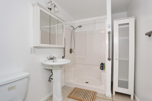 bathroom featuring tile patterned flooring, a shower, and toilet