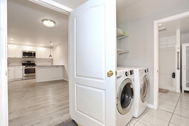 laundry room with separate washer and dryer, sink, and light tile patterned floors