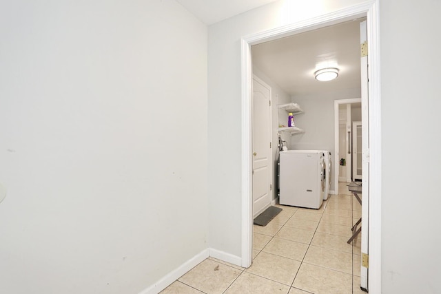 clothes washing area with washing machine and clothes dryer and light tile patterned floors