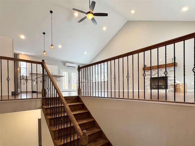 staircase featuring ceiling fan, french doors, high vaulted ceiling, and an AC wall unit