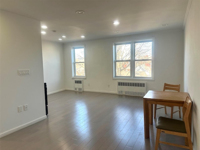 spare room featuring radiator heating unit, heating unit, and dark hardwood / wood-style floors