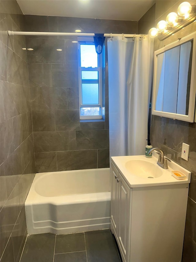 bathroom featuring shower / bath combination with curtain, vanity, tile patterned floors, tile walls, and backsplash