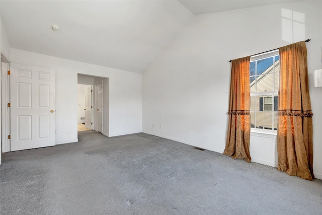 carpeted spare room with lofted ceiling