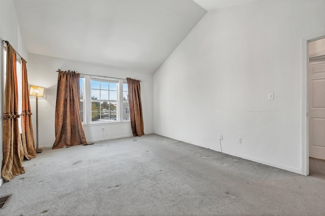 unfurnished room with vaulted ceiling and light colored carpet