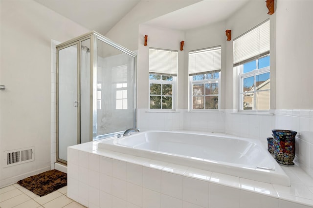 bathroom featuring vaulted ceiling, tile patterned floors, plus walk in shower, and a healthy amount of sunlight