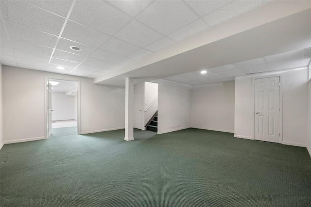 basement with dark colored carpet and a drop ceiling