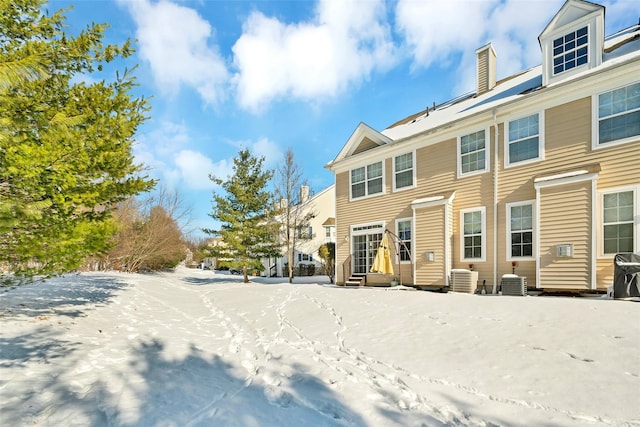 snow covered back of property with central AC unit