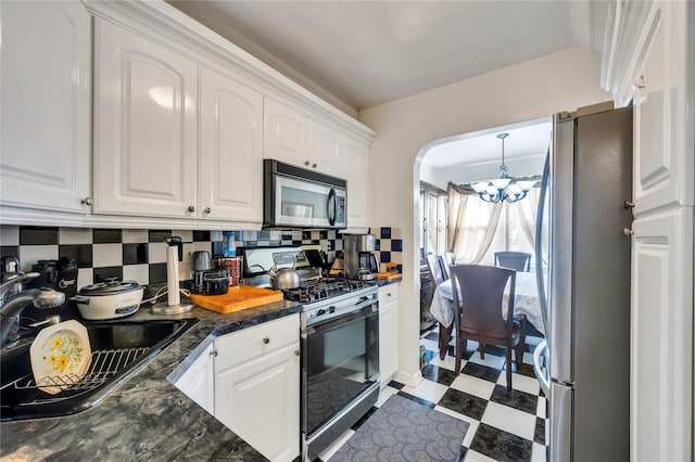 kitchen featuring stainless steel appliances, sink, white cabinets, and backsplash