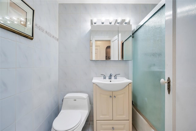 bathroom with vanity, a shower with shower door, tile walls, and toilet