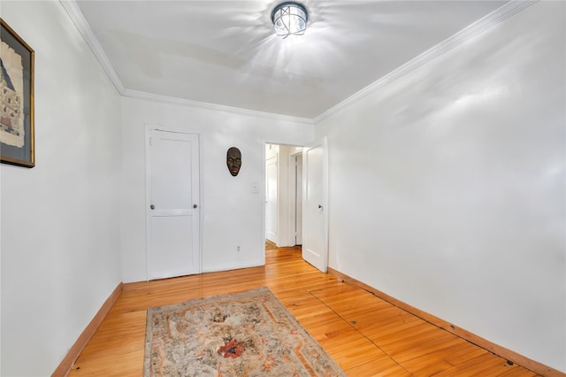 spare room with ornamental molding and light wood-type flooring