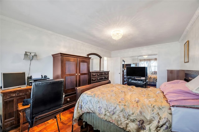 bedroom featuring hardwood / wood-style floors, crown molding, and a closet