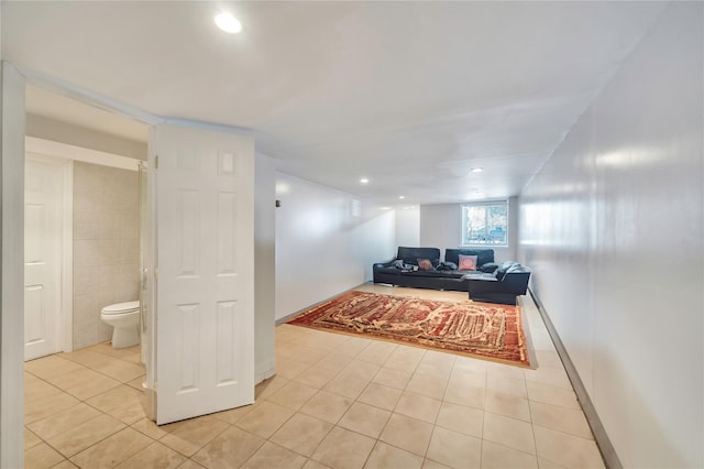 corridor featuring light tile patterned flooring and tile walls