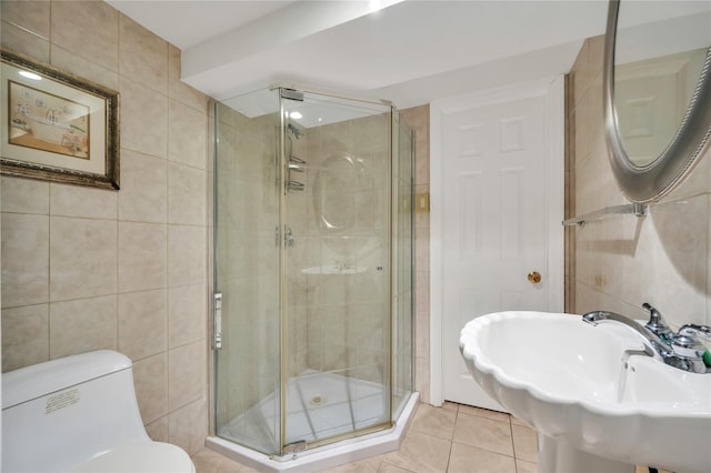 bathroom featuring tile walls, a shower with shower door, tile patterned floors, and toilet