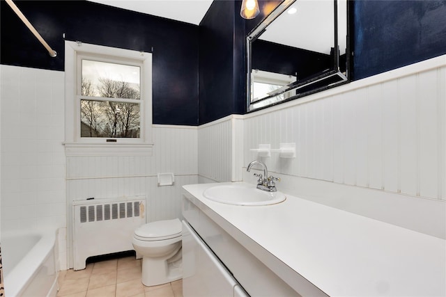 bathroom featuring tile patterned flooring, radiator heating unit, vanity, and toilet