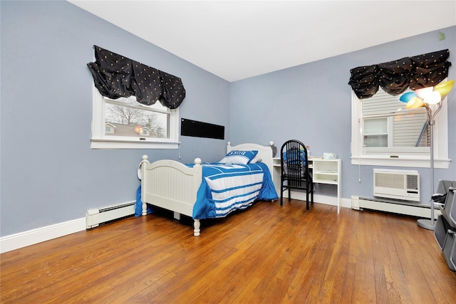 bedroom with hardwood / wood-style flooring, a wall mounted AC, and a baseboard radiator