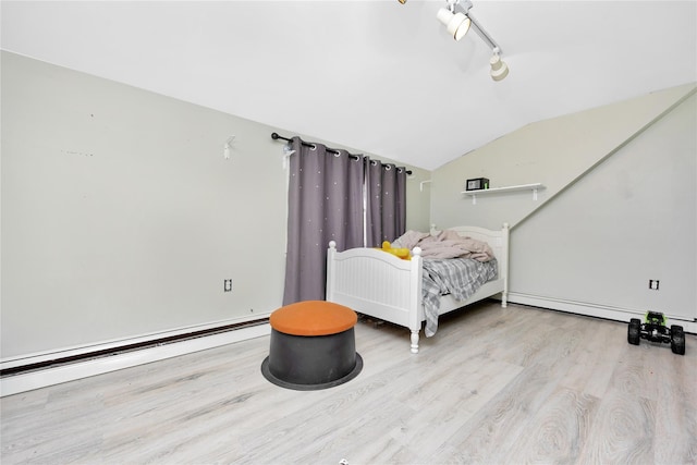 bedroom with light hardwood / wood-style floors, baseboard heating, and lofted ceiling