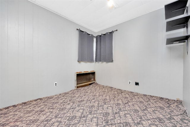 carpeted empty room with wooden walls