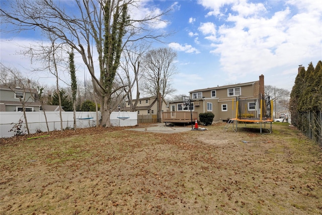 view of yard with a deck and a trampoline