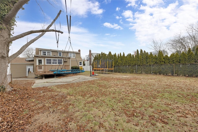 view of yard featuring a patio, a deck, and a trampoline