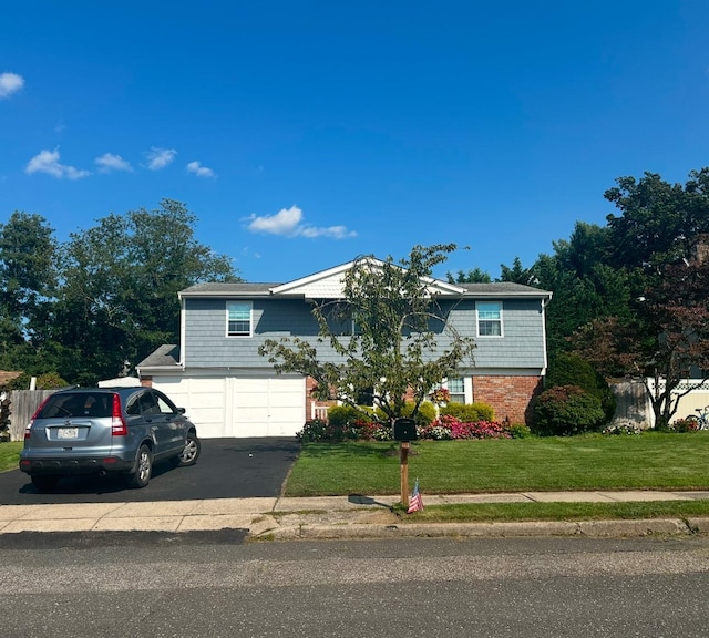 split foyer home featuring a garage and a front lawn