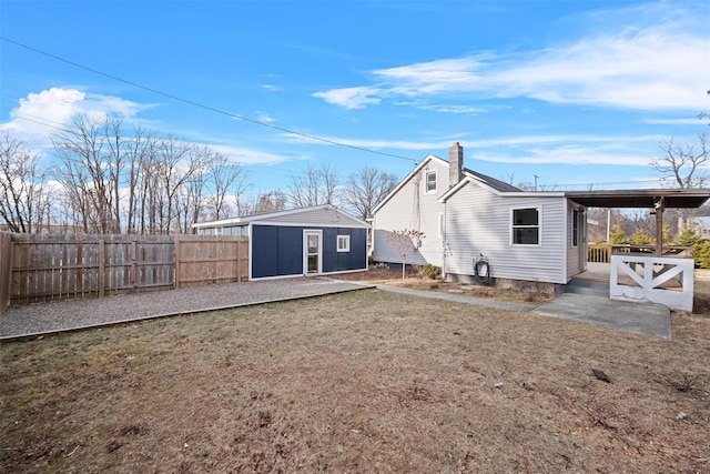 rear view of property with a lawn and a storage unit