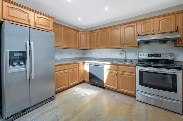 kitchen featuring sink, light hardwood / wood-style floors, decorative backsplash, stone countertops, and appliances with stainless steel finishes