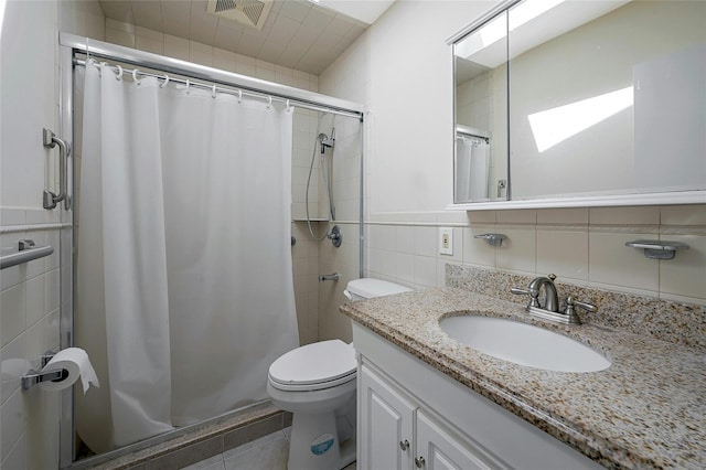 bathroom with toilet, tile walls, a shower with curtain, a skylight, and vanity